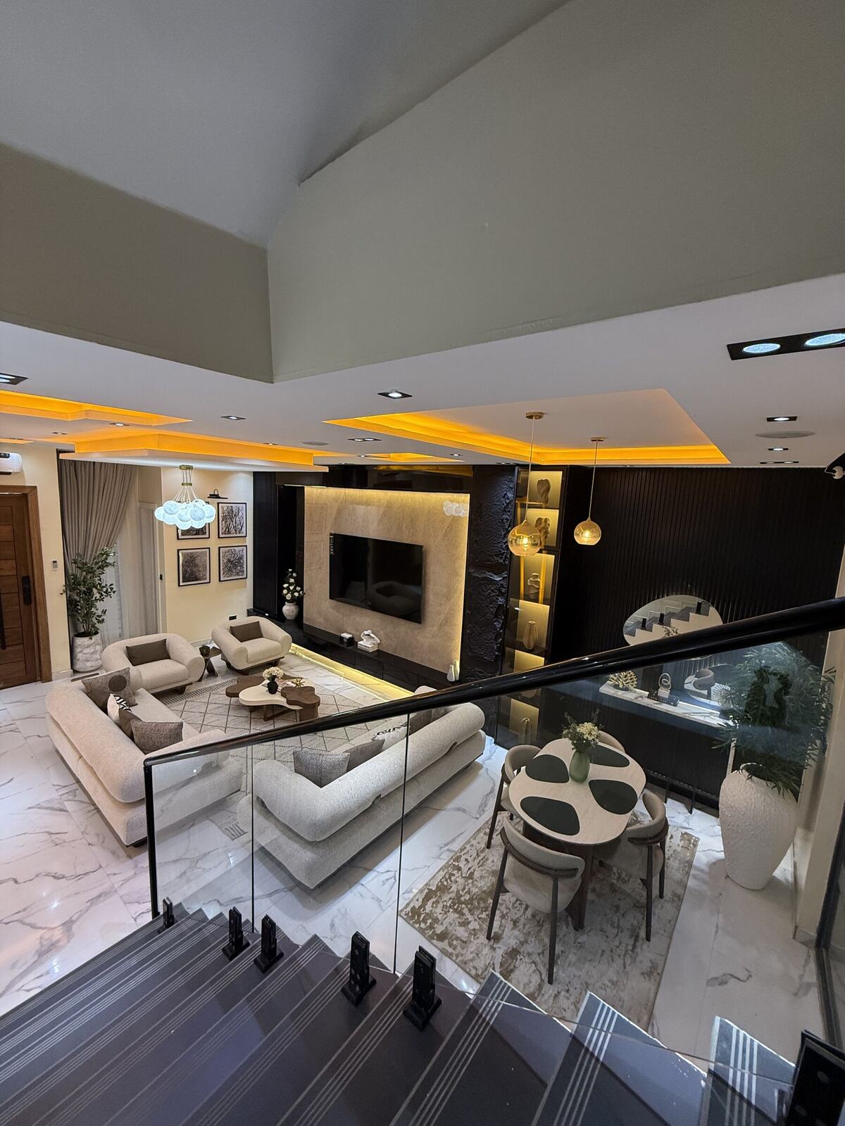Two-story living room with vaulted ceiling and staircase view